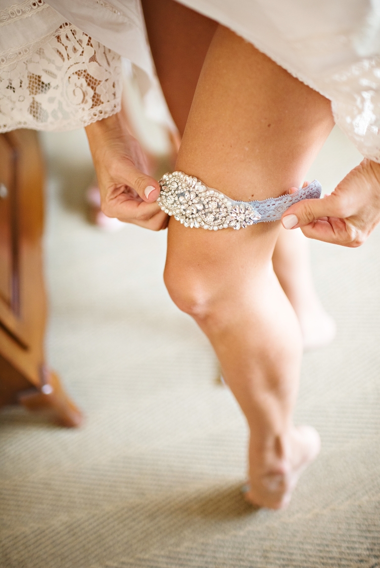 Betsy places her hand made garter onto her left leg for good luck on her wedding day. 